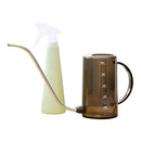 Lime brown watering tools set including a plastic watering can and spray bottle on a table.