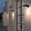 Waterproof black UFO wall light mounted on a building facade with a wooden floor background.