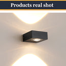 Black UFO-shaped waterproof wall light mounted on a ceiling, emitting a yellow light.