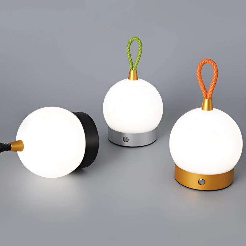 Cordless nightstand table light featuring a waterproof LED lamp blimp, designed with a metal base and artistic circular lighting, surrounded by plants.