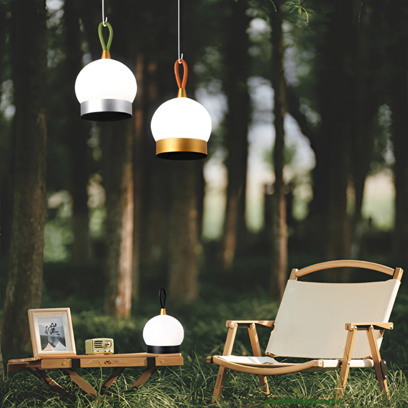 Cordless Waterproof LED Lamp Blimp on a nightstand table outdoors, surrounded by grass and leaves, with sunlight casting soft shadows.