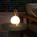 Cordless orb-shaped waterproof LED table lamp on a wooden floor, highlighting its sleek design and ambient lighting in an interior setting.