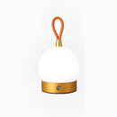 Gold cordless orb-shaped waterproof LED table lamp displayed near a tree, with metallic and wooden ornamental accents.
