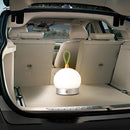 White car illuminated by a cordless, orb-designed waterproof LED table lamp, showcasing automotive design and lighting features.