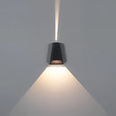 Outdoor waterproof pyramid-shaped LED wall sconce mounted on a wooden wall, emitting a soft glow.