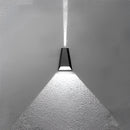 Outdoor pyramid-shaped LED wall sconce mounted on a wooden surface, featuring a waterproof design with symmetrical monochrome shades under a ceiling in a dimly lit setting.