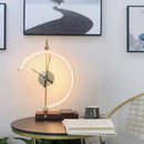 Wireless charging clock lamp with LED light and integrated clock placed on a wooden table, featuring a sleek design that enhances the interior setting.