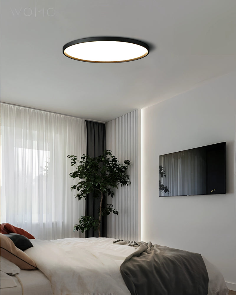 Circular LED Ceiling Light with Black Rim, Minimalist Energy-Efficient Design in Modern Interior Setting with Wooden Elements and Natural Light.