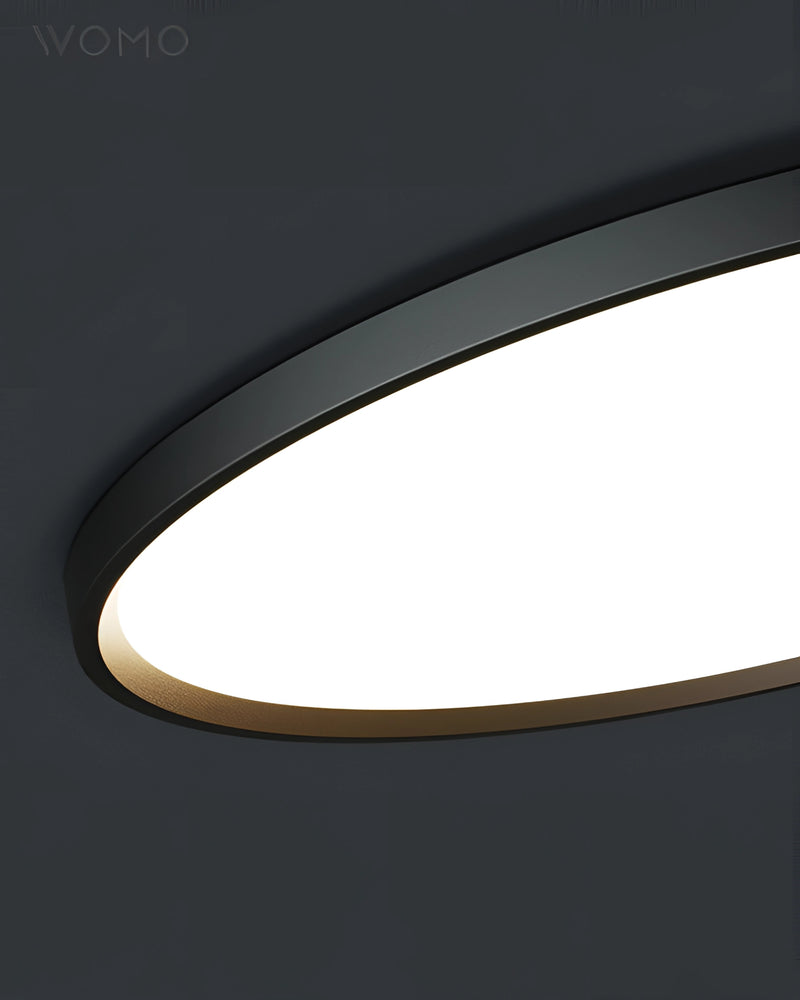 Black rimmed circular LED ceiling light, minimalist design, energy-efficient, mounted on a ceiling.