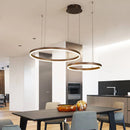 Circular LED Pendant Light with Gold Finish, Adjustable Height Chandelier in Coffee color, featuring two dimmable rings (60cm and 80cm) hanging above a modern dining table with wooden chairs and flooring in a stylish interior design setting.