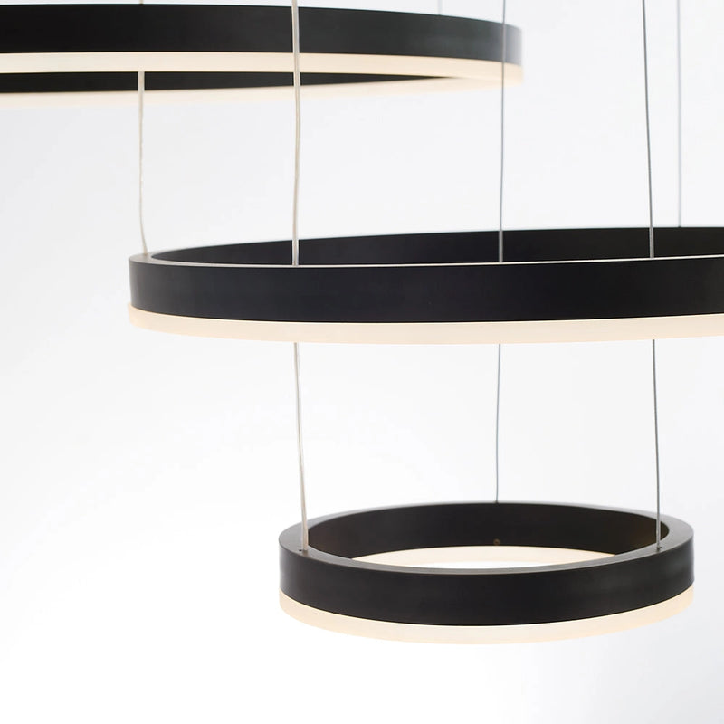 Circular LED Pendant Light with Gold Finish and Adjustable Height Chandelier, illuminating a modern grey and wood-themed room with shelving in the background.