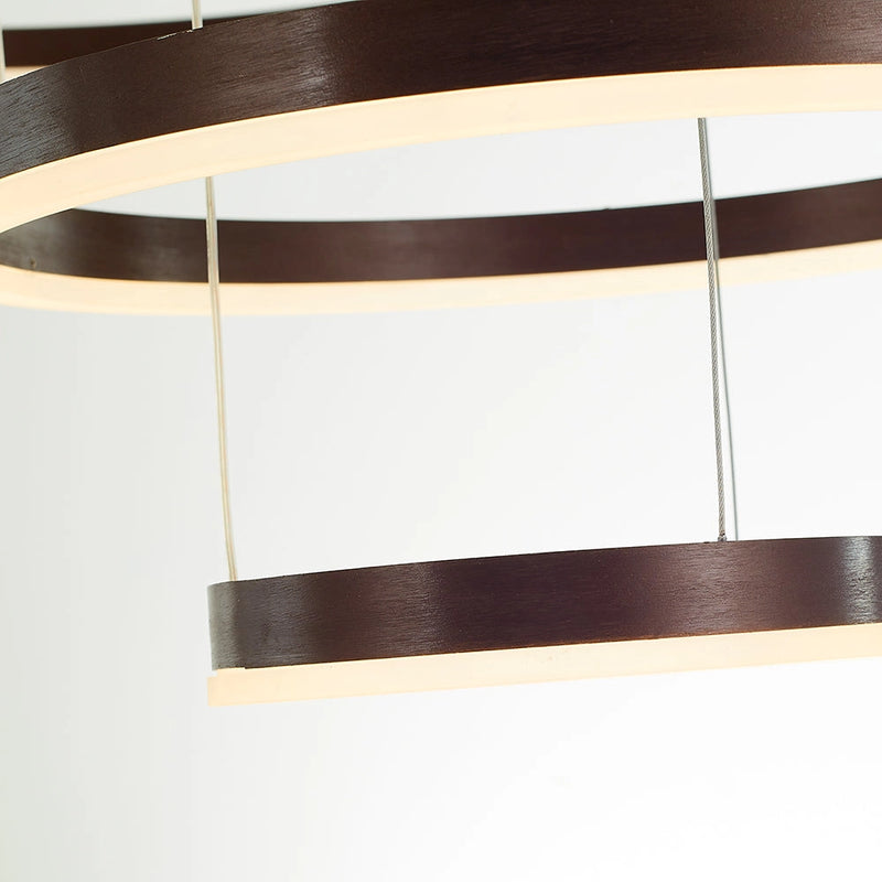 Circular LED Pendant Light with Gold Finish and Adjustable Height Chandelier hanging above a wooden table with shelving and hardwood flooring in the background.