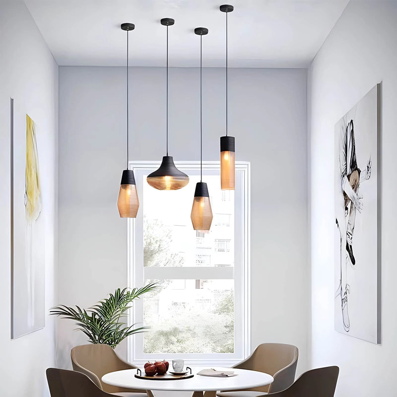 Modern industrial kitchen featuring a designer ribbed glass pendant light illuminating a wooden table with a plant, surrounded by white and black furniture.
