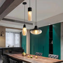 Modern industrial kitchen with a designer ribbed glass pendant light hanging above a wooden countertop and cabinetry.