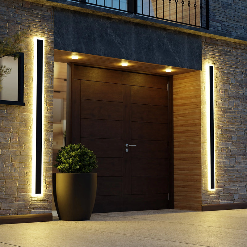 Minimalist LED wall sconce, sleek vertical rectangular light, 60W, 8x150 cm, dimmable with motion detector, mounted on a wooden wall beside a potted houseplant and near a door and window.