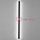 Minimalist LED wall sconce with a sleek vertical rectangular design, featuring a symmetrical electric blue light, mounted on a dark background.