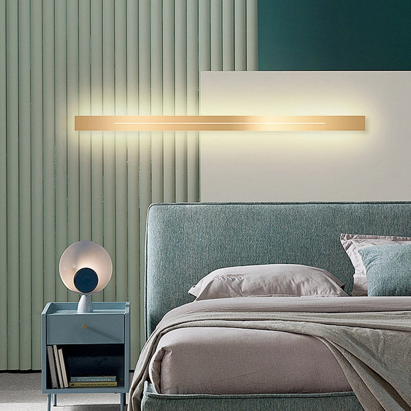 Minimalist Slim Gold Bar Pendant Necklace displayed on a wooden surface with modern interior lighting in the background.