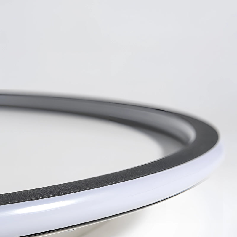 Modern circular LED ceiling light with a minimalist design, featuring a metal rim and flush mount installation.