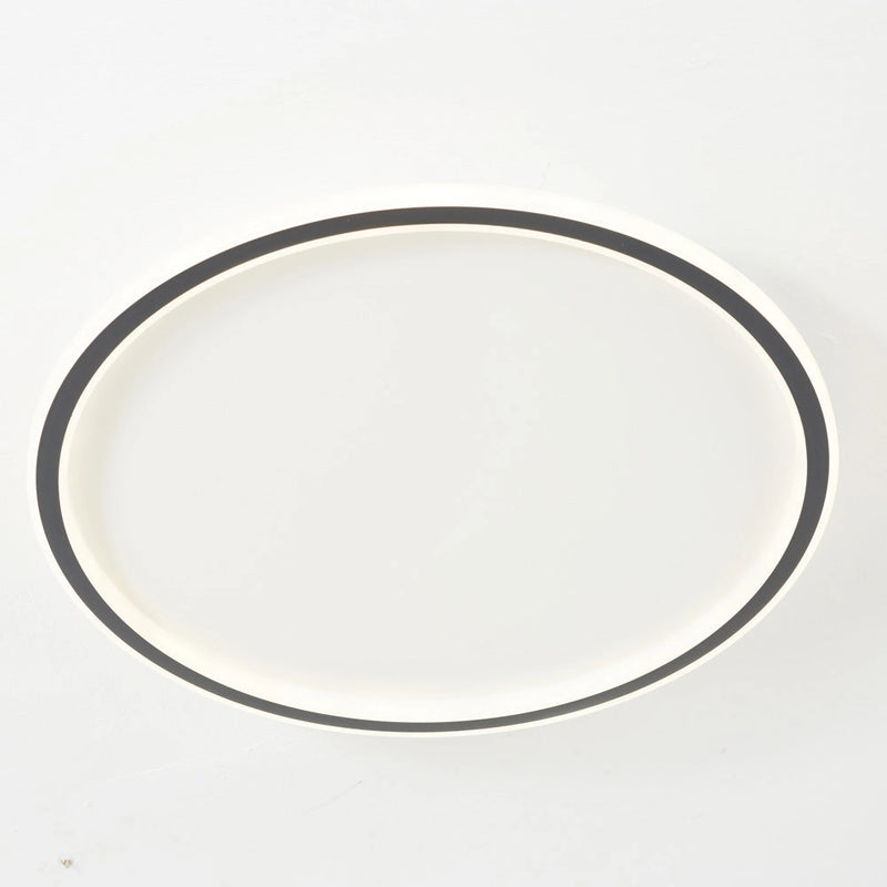 Modern LED ceiling light with minimalist circular design, flush mount, energy efficient, metal finish, installed on the ceiling.