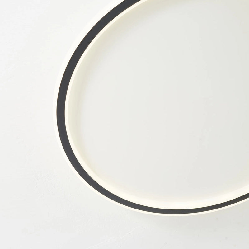 Modern LED Ceiling Light with Minimalist Circular Flush Mount, Energy Efficient, featuring a sleek metal rim and contemporary design, installed on a ceiling.