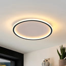 Modern LED ceiling light in black, circular flush mount design, 50CM diameter, dimmable, energy efficient, installed on the ceiling with houseplants and flowerpot in the background.