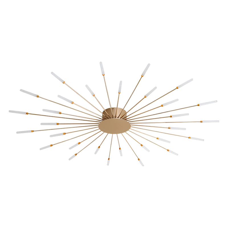 Modern starburst wall art sculpture in black and gold metal with mid-century design, displayed on a wooden background with plants and symmetrical patterns.