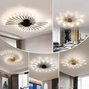 Modern starburst wall art in black and gold metal, featuring a mid-century design with intricate lines, displayed on a white wall in a well-lit interior space.