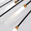 Modern starburst wall art in black and gold metal with mid-century design displayed against a wooden background.