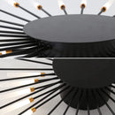 A modern starburst wall art sculpture in black and gold metal with mid-century design elements.