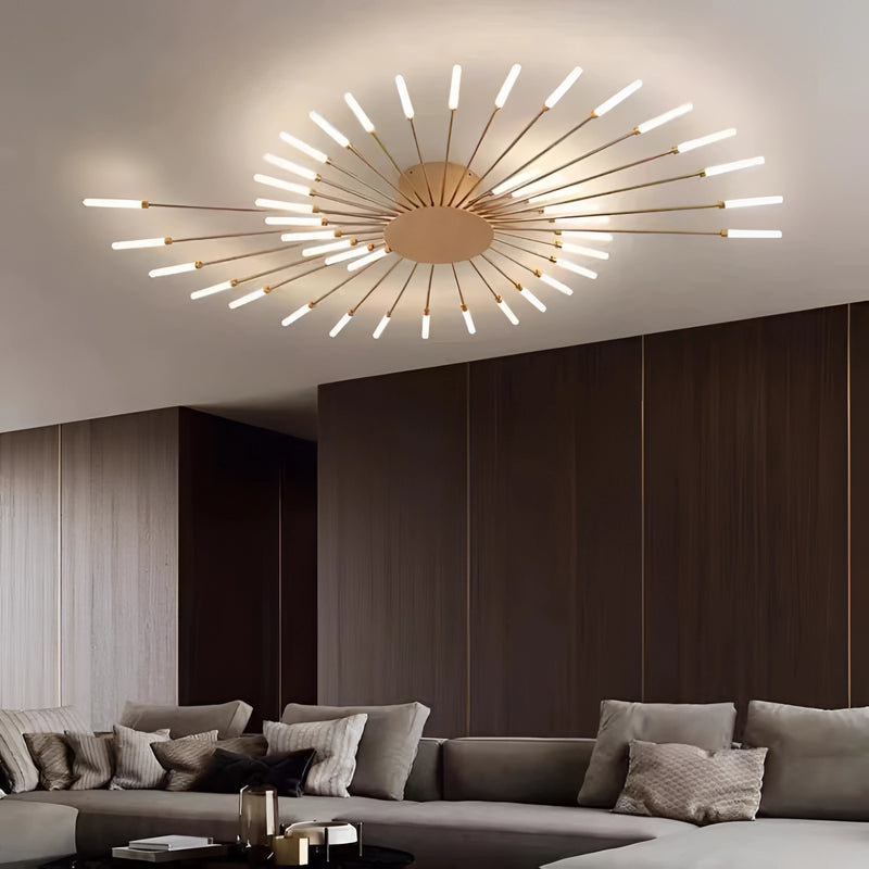 Modern starburst wall art in black and gold metal, dimmable, mounted on a wooden wall above a brown couch in a mid-century styled living room.