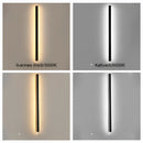 Slim Vertical LED Wall Sconce mounted on a wall next to a door, showcasing its minimalist rectangular design and metal fixture, with light illuminating in parallel lines.