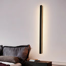 Slim Vertical LED Wall Sconce - Minimalist Waterproof Light, 100CM Dimmable, mounted on a wall above a modern couch with wooden flooring and minimalist decor.