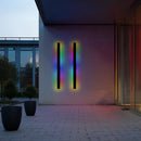 Minimalist waterproof Slim Vertical LED Wall Sconce in 100CM size with RGB lighting and motion sensors, mounted on a modern building exterior near a plant and flowerpot.
